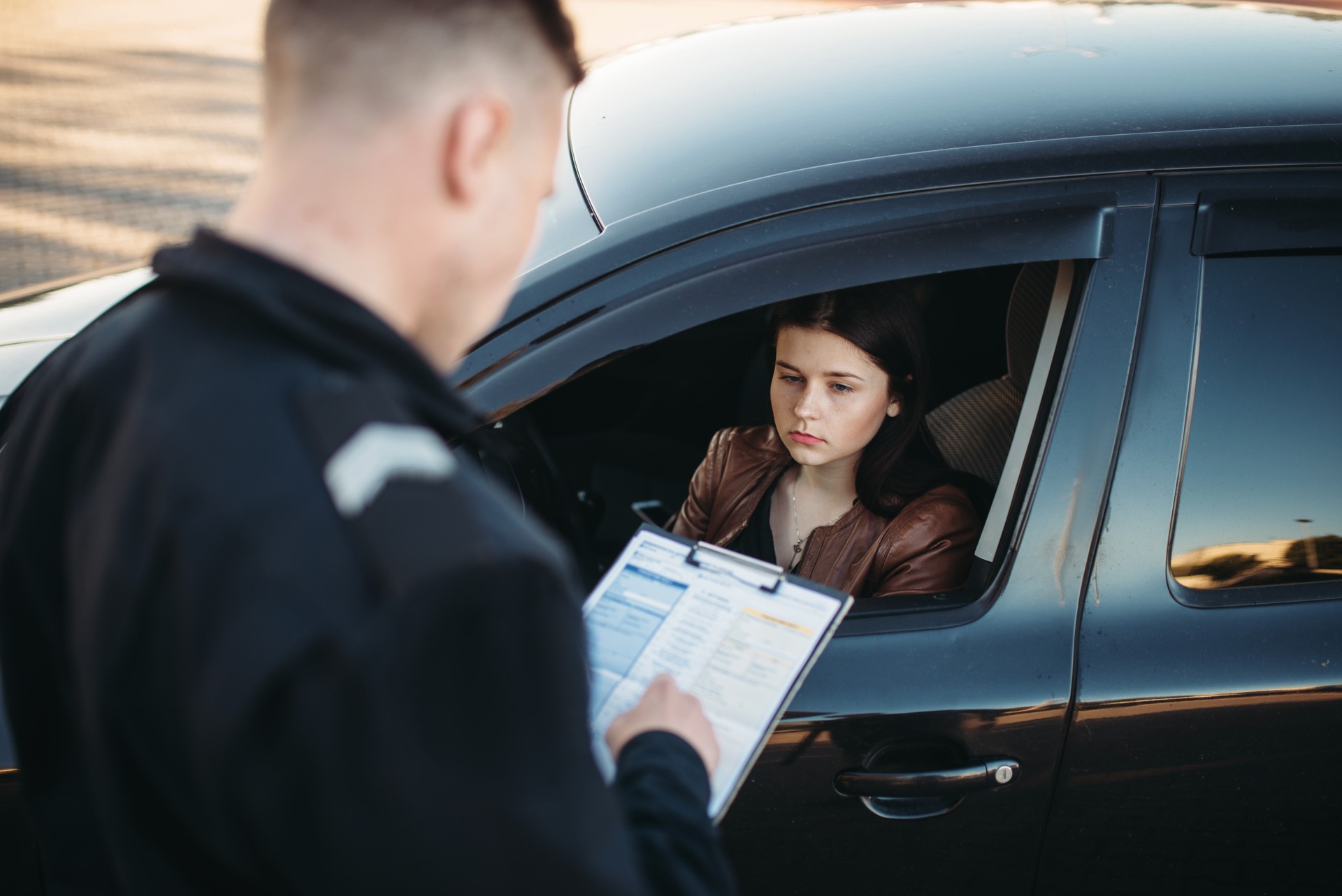 Policeman in uniform writes fine to female driver